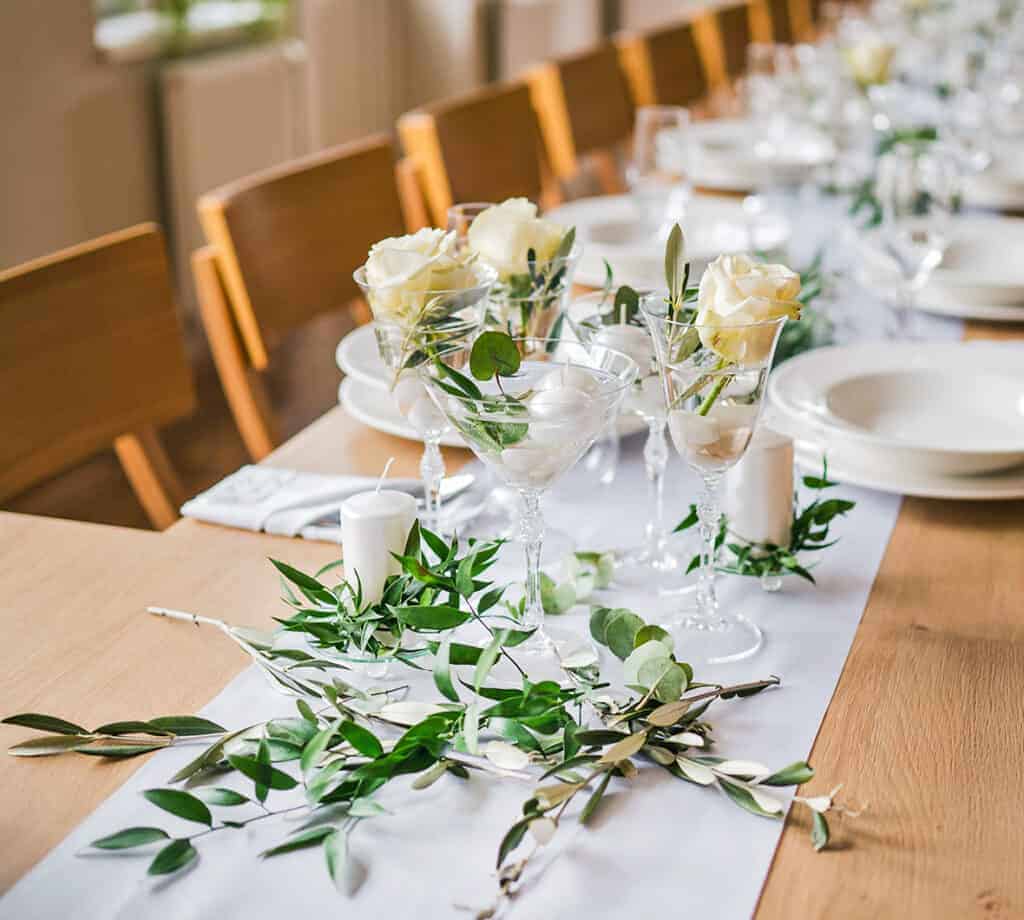 Elegantní svatební hostina s květinovou výzdobou a svíčkami.