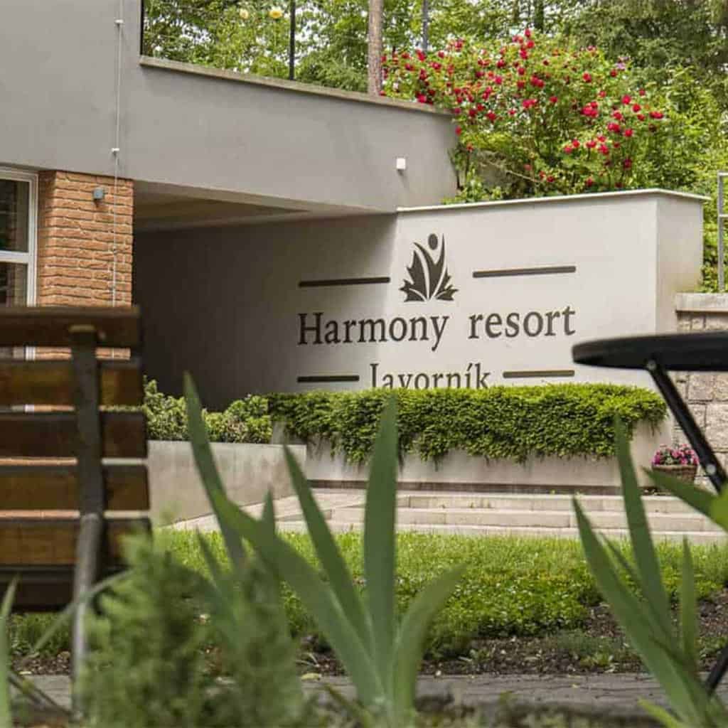 Exteriér Harmony resort Javorník s nápisem a zahradou.